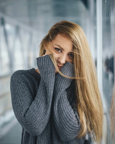 女人在灰色的针织毛衣的脸颊
